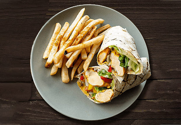 Zabiha Halal chicken wrap filled with lettuce, tomato, cucumber, jalapeños, and garlic sauce served with fries at La Peri Peri in Sterling Heights