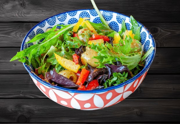 Fresh Olivia Salad with mixed greens, olives, and tomatoes served in a bowl at La Peri Peri Sterling Heights