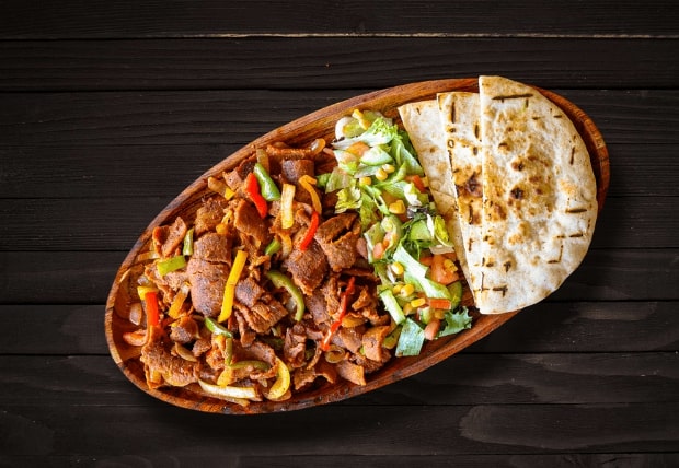 Spicy Naga beef doner sautéed with onions and peppers, served with naan at La Peri Peri in Sterling Heights, Michigan