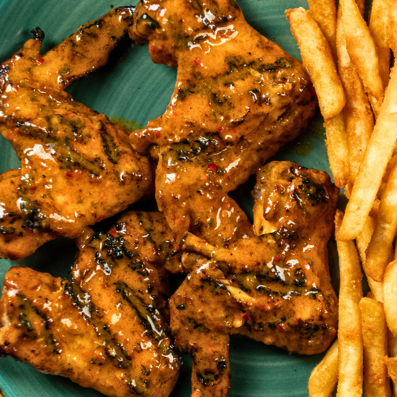 Zabiha Halal grilled chicken wings served with seasoned rice at La Peri Peri Sterling Heights