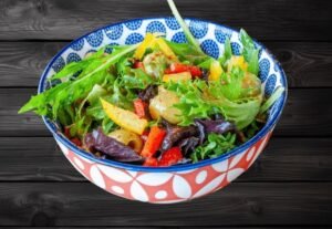 Fresh Olivia Salad with mixed greens, olives, and tomatoes served in a bowl at La Peri Peri Sterling Heights