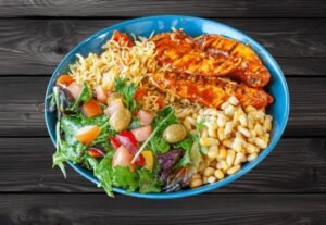 Peri-peri rice bowl with grilled chicken tenders, Portuguese rice, mixed vegetables, and spring mix at La Peri Peri Sterling Heights