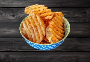 Crisscross-cut waffle fries served in a patterned bowl at La Peri Peri Sterling Heights