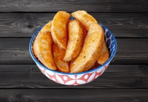 Golden potato wedges served in a colorful bowl at La Peri Peri in Sterling Heights