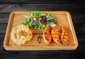 Zabiha Halal peri peri chicken tenders served with seasoned rice and fresh salad at La Peri Peri Sterling Heights